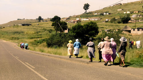 Rear view of people walking on road