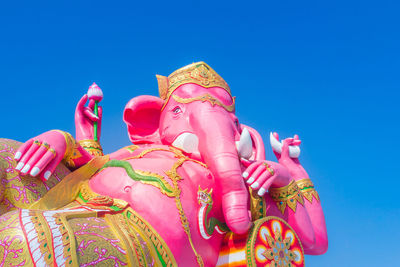 Low angle view of statue against blue sky