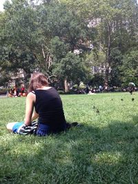 People relaxing on grassy field in park