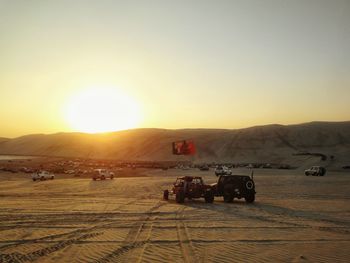 Sport utility vehicle on desert at sunset