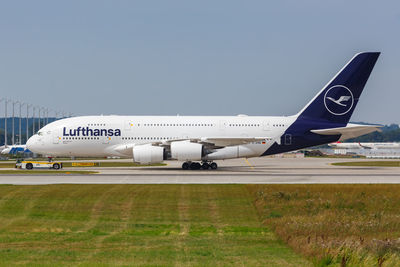 Airplane on runway against sky