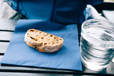 Close-up of brown bread and water in glass on table