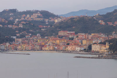 Aerial view of townscape by mountain against sky