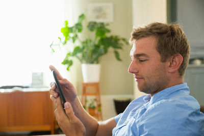 Young man using phone at home