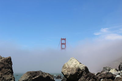 Golden gate bridge during foggy weather against sky on sunny day