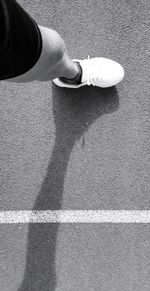 Low section of person standing on road