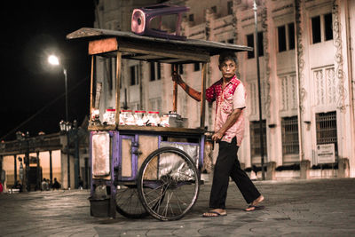 Portrait of man with bicycle standing on street