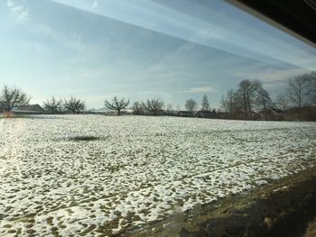 Scenic view of snow covered field against sky