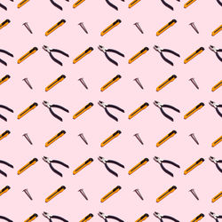 Pliers, self-tapping screws and knives on a pink background, pattern, hard shadows. 
