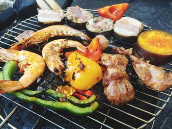 High angle view of vegetables and meat cooking on barbecue grill