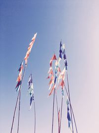 Low angle view of flags against clear sky