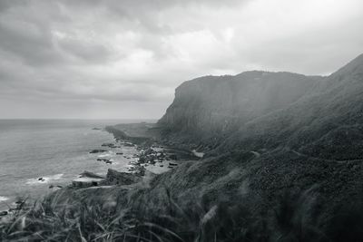 Scenic view of sea and mountains against sky