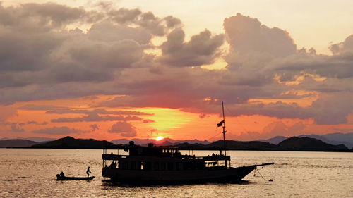 Silhouette sailboats in sea against sky during sunset