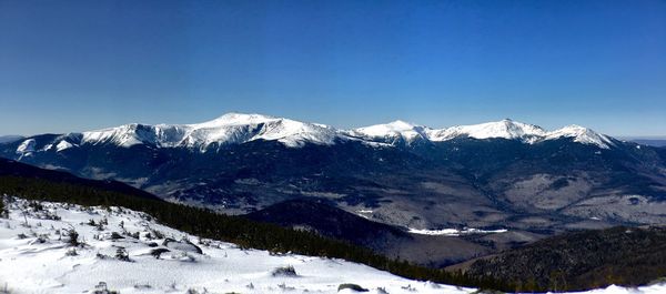 Scenic view of snowcapped mountains against clear sky