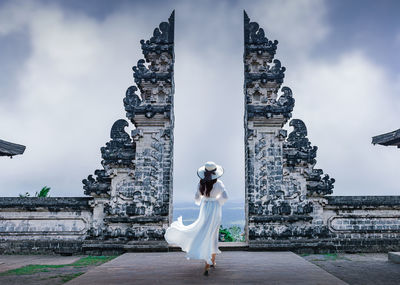 Rear view of woman standing against historic structure