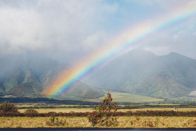 Scenic view of rainbow over mountains against sky