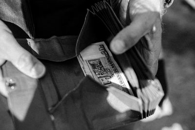 Cropped hands of man holding wallet with paper currency