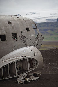 Abandoned airplane on field against sky