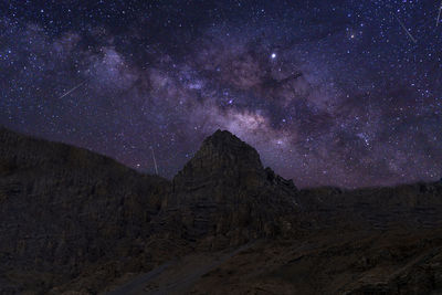 Scenic view of mountains against sky at night