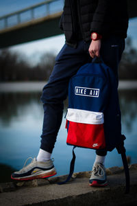 Low section of man standing by lake