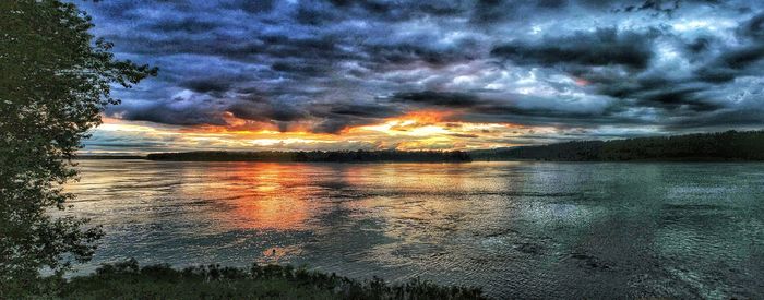 Scenic view of sea against dramatic sky during sunset