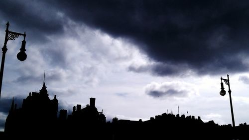 Silhouette of buildings against cloudy sky