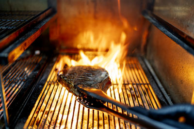 Meat being roasted on barbecue grill at restaurant