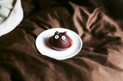 High angle view of chocolate candy in plate on bed