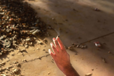 High angle view of woman hand holding cigarette