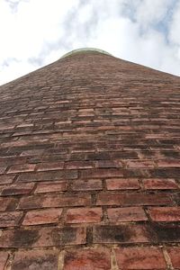 Low angle view of brick wall against sky