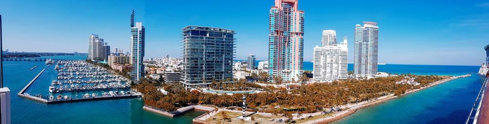 Modern buildings by swimming pool in city against sky