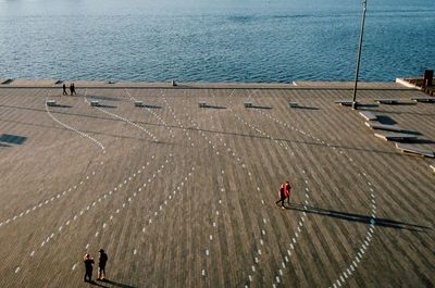 High angle view of people walking against the sea