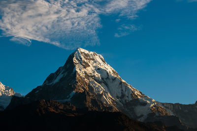 Scenic view of snowcapped mountains against blue sky