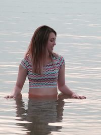 Smiling young woman in lake