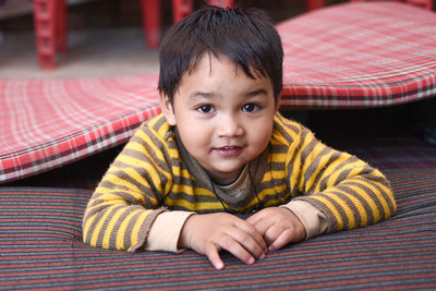 Portrait of baby boy lying on mattress