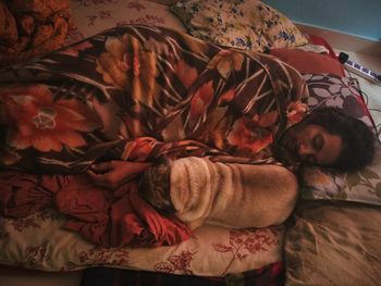 Close-up of young woman sleeping on bed at home