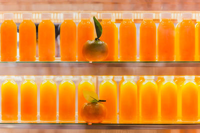 Fresh orange juice in bottles in refrigerator shelf.