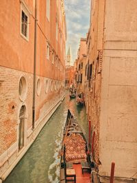 Canal amidst buildings against sky