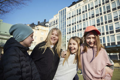 Portrait of smiling friends in front of school