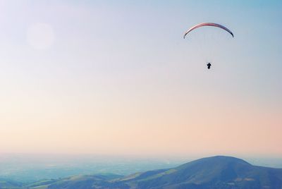 Person paragliding against sky