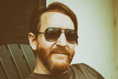 Man with beard wearing sunglasses smiling at camera
