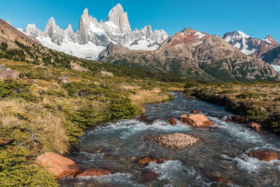 Scenic view of river amidst snowcapped mountains against sky