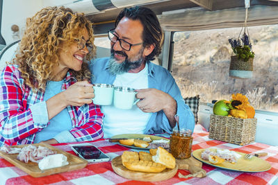 Portrait of smiling friends having food at home