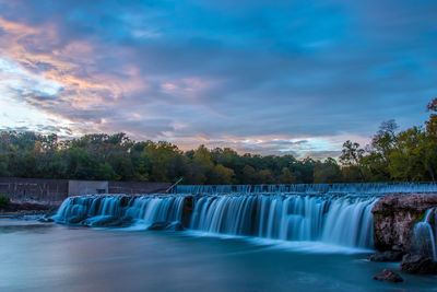 Scenic view of waterfall against sky