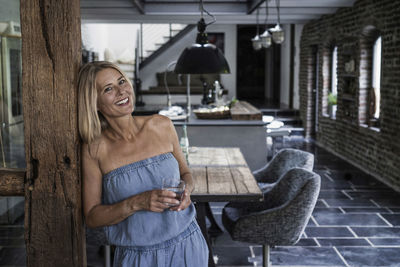 Woman standing in her comfortable country house, smiling