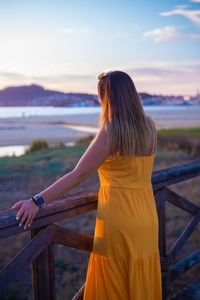 Rear view of woman looking at sea against sky