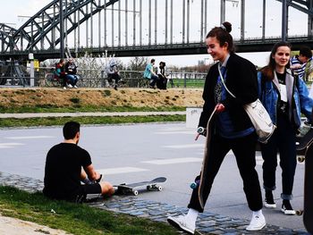 People sitting on bridge over water