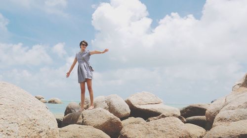 Low angle view of man with arms raised against sky