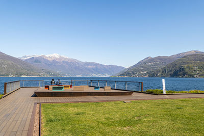 Luino viewpoint on lake maggiore with two tourists sitting on a bench