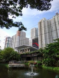 Buildings by lake against sky in city